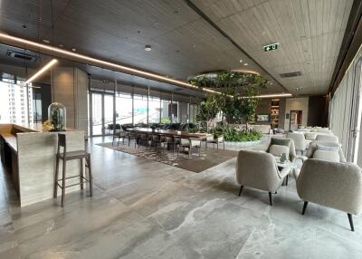 Modern common area with seating, dining table, and indoor greenery