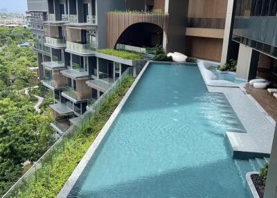 Modern apartment building with swimming pool and greenery