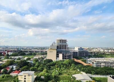 Panoramic view of urban and green areas with buildings and cloudy sky