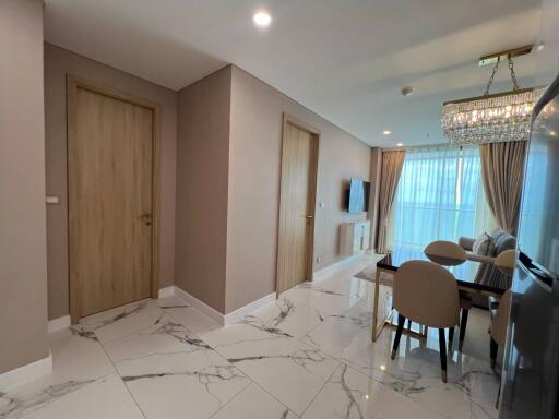 Modern living room and dining area with marble flooring and chandelier