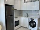 Modern kitchen with sleek white cabinetry, marble flooring, and built-in appliances