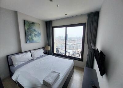 Bedroom with a large window overlooking a cityscape