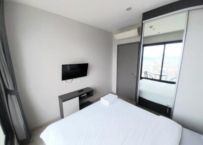 Bedroom with a TV, mirror, and an air conditioning unit