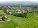 Aerial view of a plot of land with surrounding greenery and houses