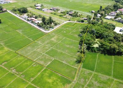 Aerial view of a large plot of land surrounded by greenery.