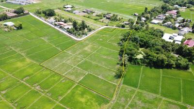 Aerial view of a large plot of land surrounded by greenery.