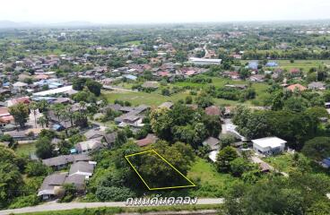 Aerial view of a residential area with available plot marked