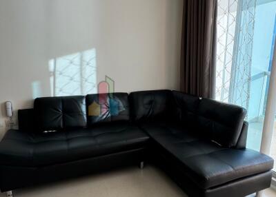 Modern living room with black leather sectional sofa.