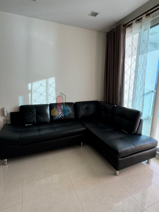 Modern living room with black leather sectional sofa.