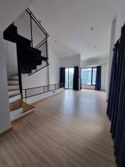 Spacious Main Living Area with Staircase and Large Windows