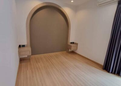 Bright bedroom with wooden floor and built-in shelving