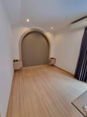 Bright bedroom with wooden floor and built-in shelving