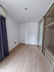 Empty bedroom with wooden flooring and built-in wardrobe