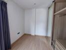 Empty bedroom with wooden flooring and built-in wardrobe