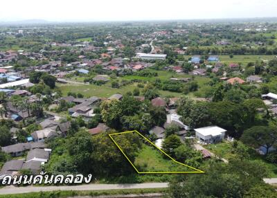 Aerial view of a residential area with a highlighted plot of land