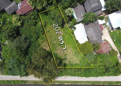 Aerial view of a plot of land surrounded by residential buildings and greenery