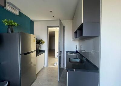 Modern kitchen with stainless steel fridge and dark cabinetry