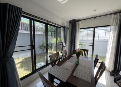 Bright dining area with wooden table set and large windows