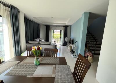 Modern living and dining space with grey curtains and sectional sofa