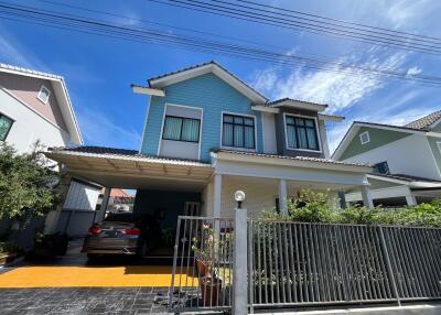 Front view of a modern two-story house with a driveway and garden