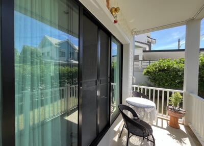 A cozy balcony with chairs and a table overlooking a view