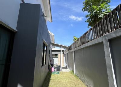 Narrow side yard with grass and side wall