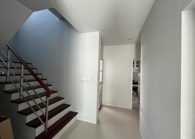 Modern hallway with staircase and adjacent kitchen