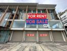 Front view of a commercial building with 'For Rent' and 'For Sale' signs