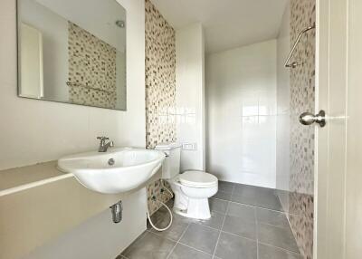 Modern bathroom with sink, toilet, and tiled walls