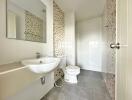 Modern bathroom with sink, toilet, and tiled walls