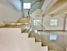 Modern white staircase in open space with large windows