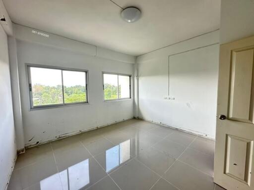 Empty bedroom with large windows and tiled floor