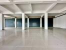 Spacious commercial area with tiled flooring and roller shutter doors