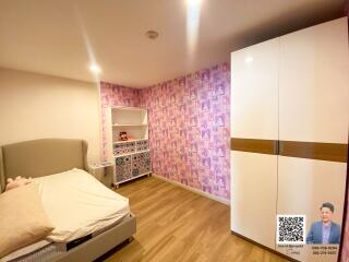 Modern bedroom with patterned accent wall and wardrobe