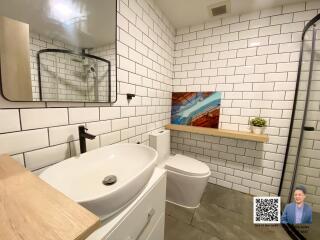 Modern bathroom with white subway tiles, a round vessel sink, and a wall-mounted mirror