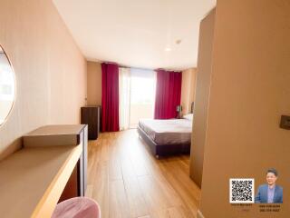 Bright bedroom with wooden flooring and large window