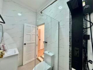 Modern bathroom with large mirror and white marble walls