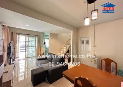 Main living area with dining table, sofa, and TV