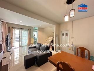 Main living area with dining table, sofa, and TV