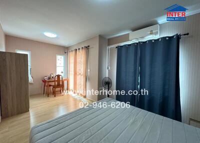 Spacious bedroom with a bed, a desk, and air conditioning