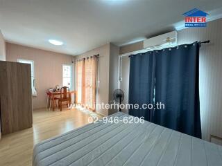 Spacious bedroom with a bed, a desk, and air conditioning