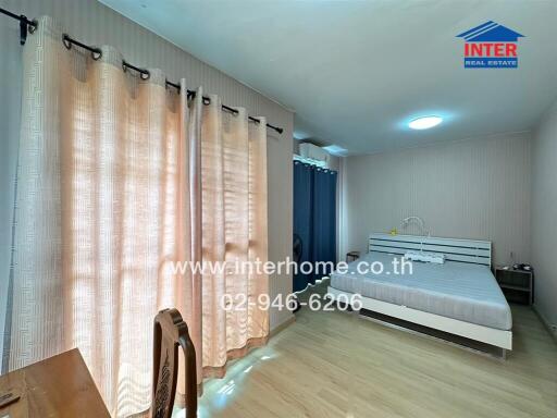 Bright and spacious bedroom with large windows and double bed