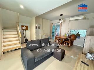 Bright living room with staircase and dining area