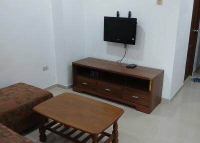 Cozy living room with TV, air conditioning, and a coffee table