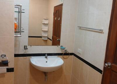 Bathroom with a sink, mirror, towel rail, and shelving