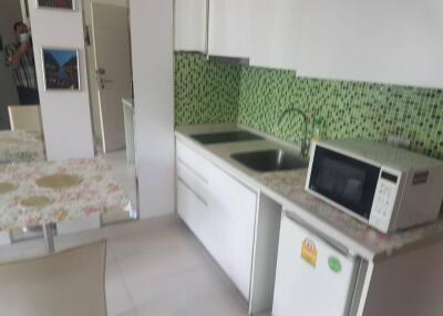 Modern kitchen with green tile backsplash and white cabinetry