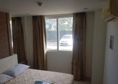 Bedroom with bed, window, and curtains