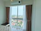 Bedroom with large window and city view