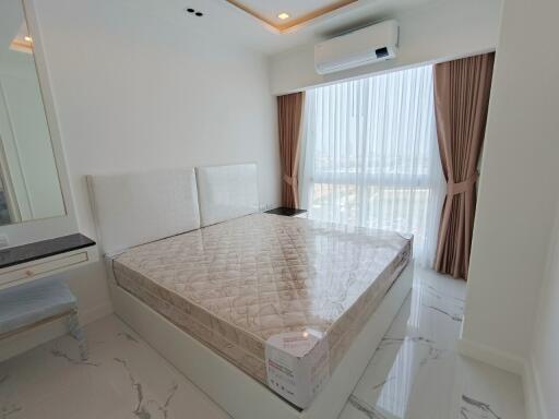 Modern bedroom with large bed, air conditioning, and large window with curtains.