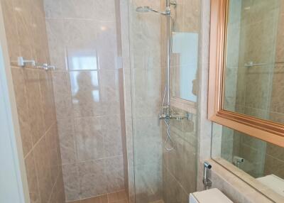 Modern bathroom with glass shower partition and checkered tile design